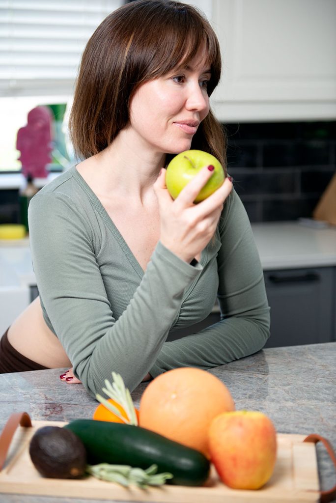 Women standing with fruit.