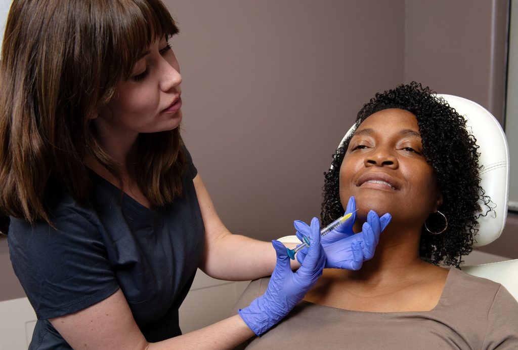 Dr Stephanie injecting a chin filler to Patient in her Gilbert, AZ aesthetics office.