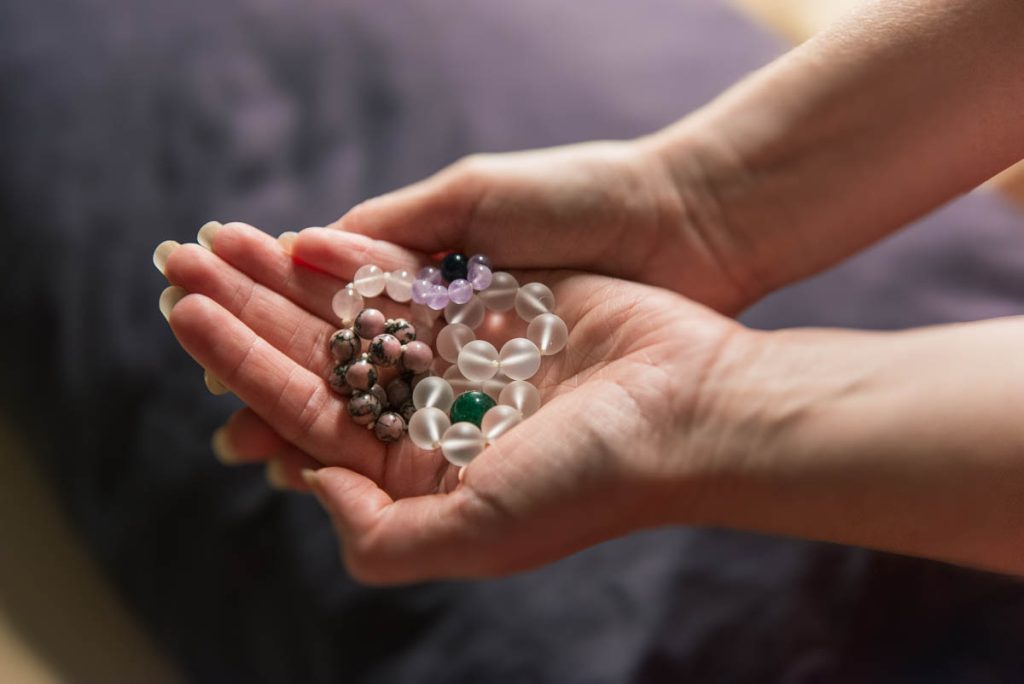 Woman holding handfuls of Gemstones for Acupuncture.