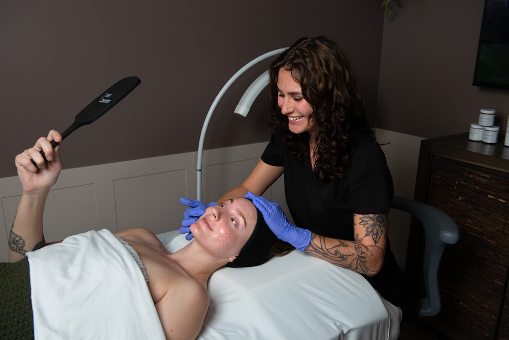 Madison looking at patients skin at Gilbert, AZ Onyx location.