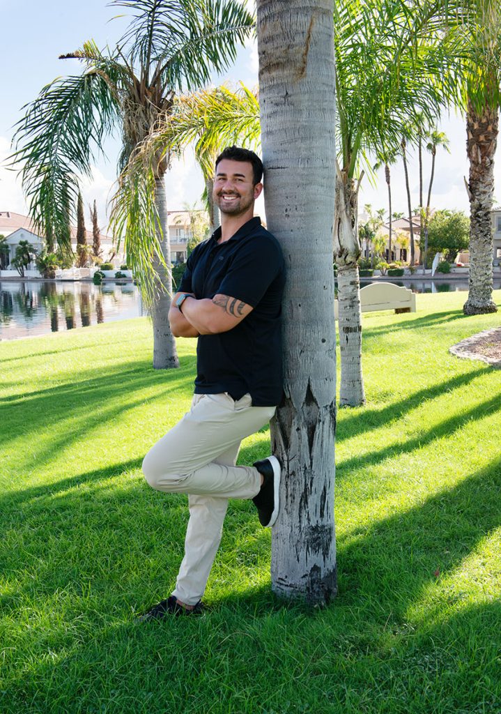 Man leaning on tree in Gilbert, AZ. He is happy.